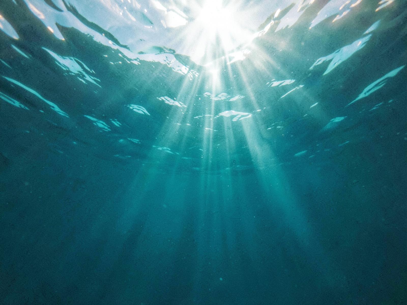 Sunlight streaming through deep blue ocean water